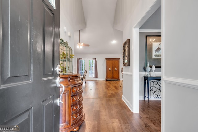 entrance foyer featuring ornamental molding, lofted ceiling, baseboards, and wood finished floors