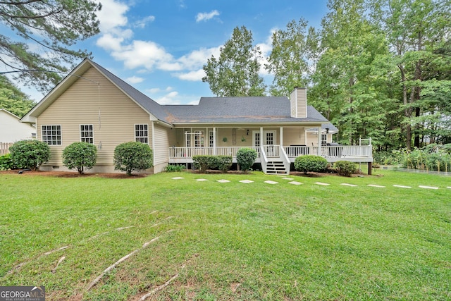 rear view of house featuring covered porch, a lawn, and a chimney