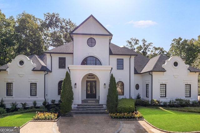 view of front of home with a front yard and french doors