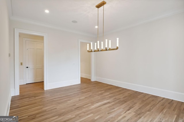 unfurnished dining area featuring a chandelier, ornamental molding, and light wood-type flooring