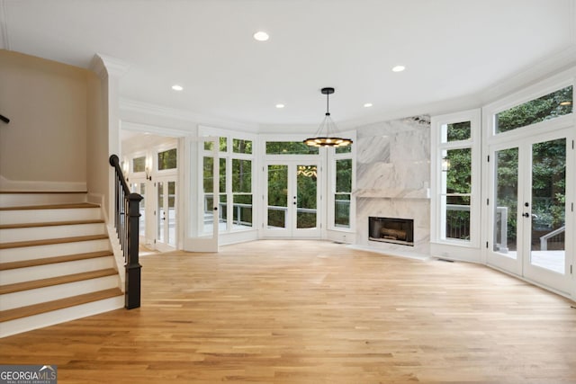 unfurnished living room featuring french doors, light hardwood / wood-style flooring, and plenty of natural light