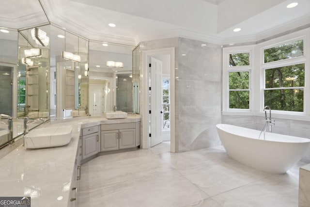 bathroom featuring vanity, ornamental molding, tile walls, and a washtub