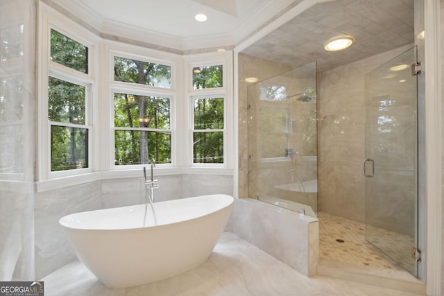 bathroom featuring separate shower and tub, tile walls, and crown molding