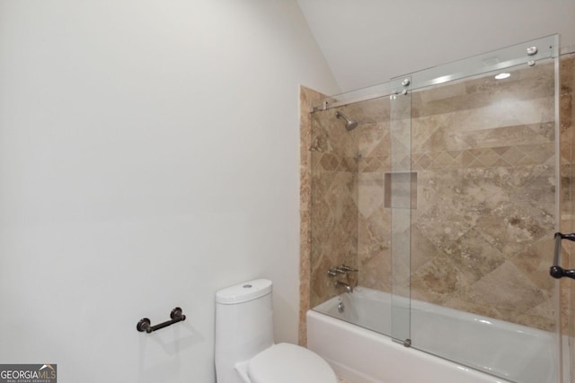 bathroom featuring toilet, lofted ceiling, and bath / shower combo with glass door