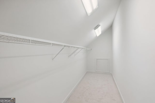 spacious closet featuring light carpet and vaulted ceiling