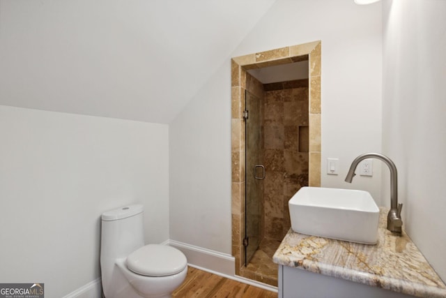 bathroom featuring toilet, hardwood / wood-style flooring, vaulted ceiling, and an enclosed shower