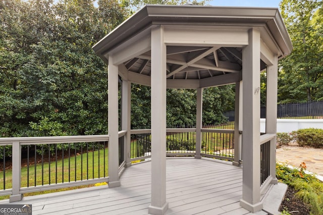 wooden terrace with a gazebo and a lawn