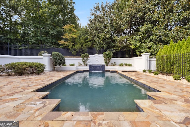 view of pool with pool water feature and a patio