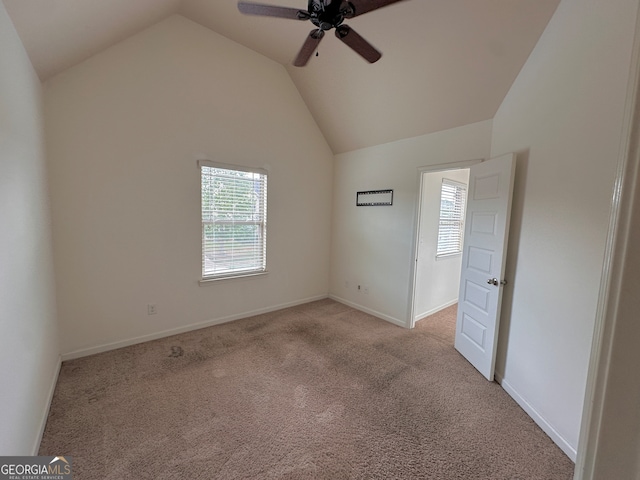 unfurnished bedroom with ceiling fan, light colored carpet, and vaulted ceiling