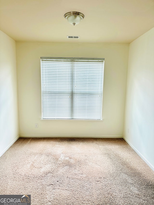 unfurnished room featuring a wealth of natural light and carpet