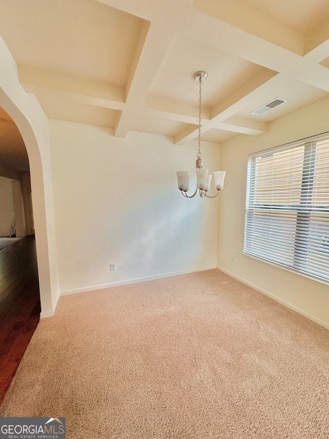 empty room featuring carpet, coffered ceiling, beamed ceiling, and a chandelier