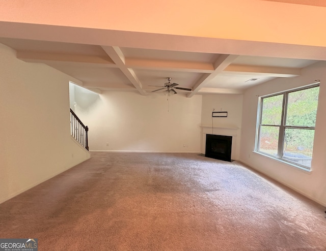 unfurnished living room featuring beamed ceiling, coffered ceiling, ceiling fan, and carpet floors