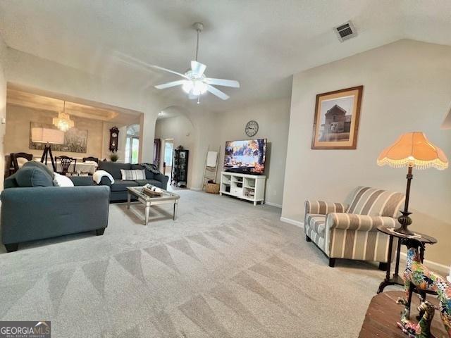 carpeted living room featuring ceiling fan, baseboards, visible vents, and vaulted ceiling