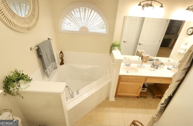 bathroom with a garden tub, vanity, and tile patterned floors