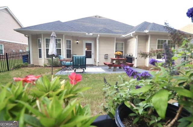 rear view of house with a patio and fence