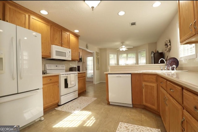 kitchen with a healthy amount of sunlight, white appliances, visible vents, and a sink