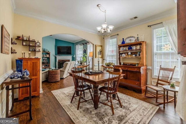 dining space with crown molding, dark hardwood / wood-style flooring, and a notable chandelier