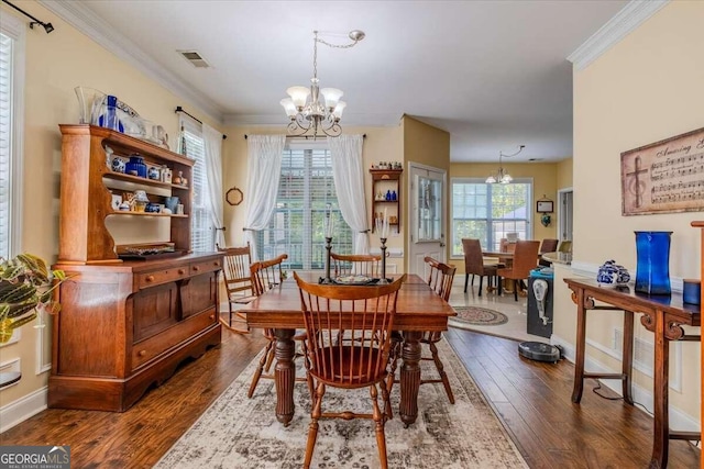 dining area featuring dark wood-type flooring, a healthy amount of sunlight, and an inviting chandelier