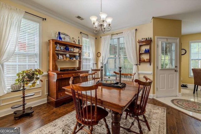 dining area with dark hardwood / wood-style floors, a chandelier, and crown molding