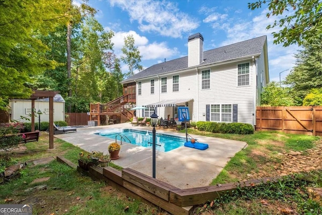 back of property featuring a fenced in pool, a storage shed, and a patio