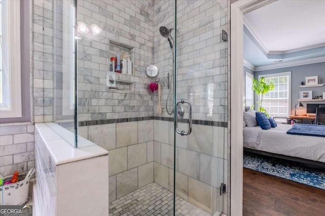 bathroom with a shower with shower door, ornamental molding, and hardwood / wood-style floors