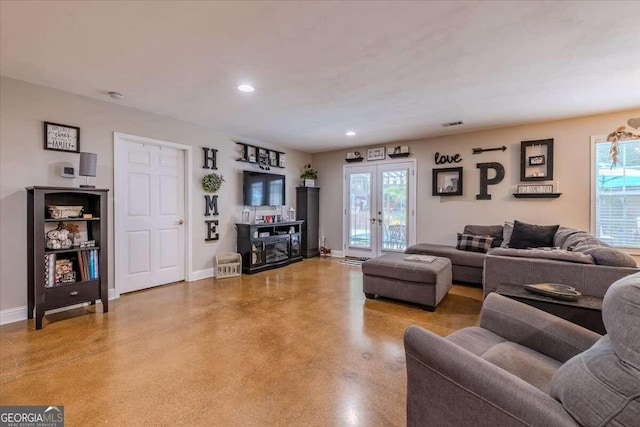 living room featuring plenty of natural light, concrete floors, and french doors