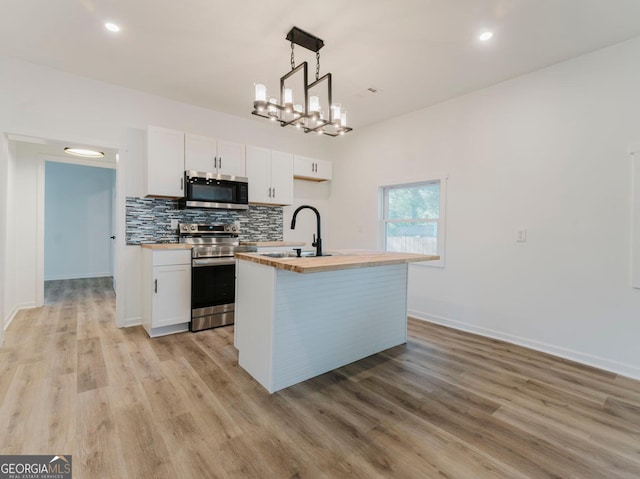 kitchen featuring white cabinets, a center island with sink, stainless steel appliances, and sink