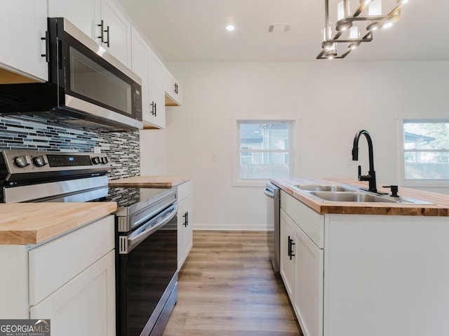 kitchen featuring white cabinetry, a healthy amount of sunlight, and stainless steel appliances