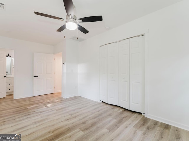 unfurnished bedroom featuring a closet, light hardwood / wood-style floors, and ceiling fan