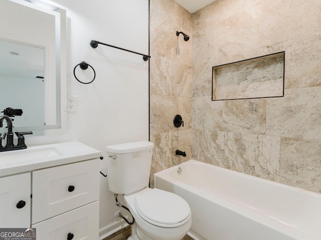 full bathroom featuring vanity, tiled shower / bath combo, and toilet