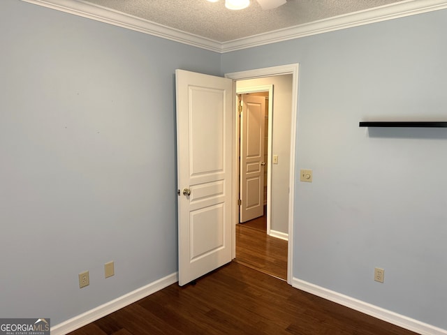 unfurnished room featuring ceiling fan, dark hardwood / wood-style flooring, crown molding, and a textured ceiling