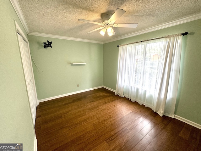 empty room featuring ceiling fan, dark hardwood / wood-style floors, a textured ceiling, and ornamental molding