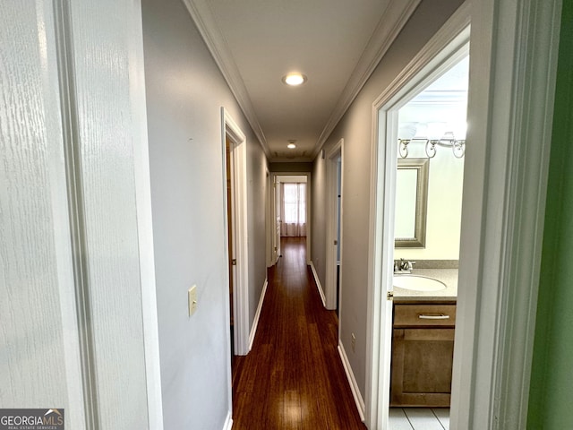 corridor with ornamental molding, hardwood / wood-style floors, and sink