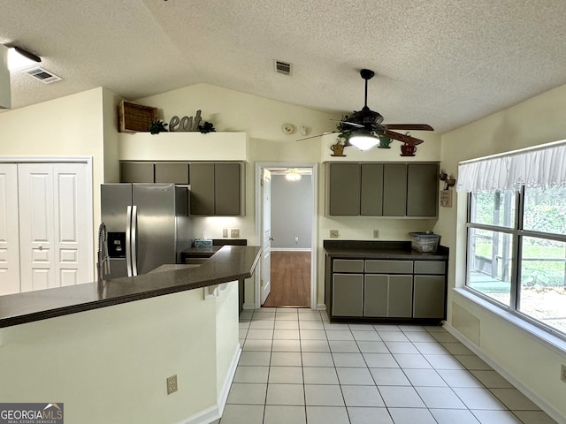 kitchen with vaulted ceiling, light tile patterned floors, stainless steel fridge with ice dispenser, gray cabinets, and ceiling fan