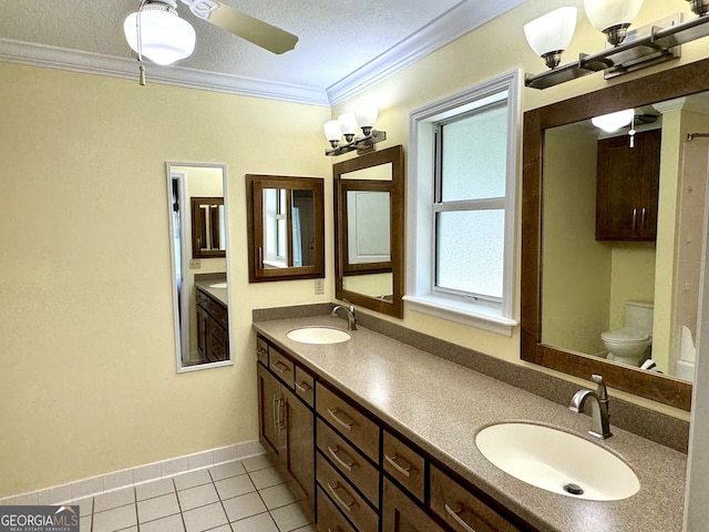 bathroom with toilet, tile patterned flooring, ornamental molding, vanity, and a textured ceiling