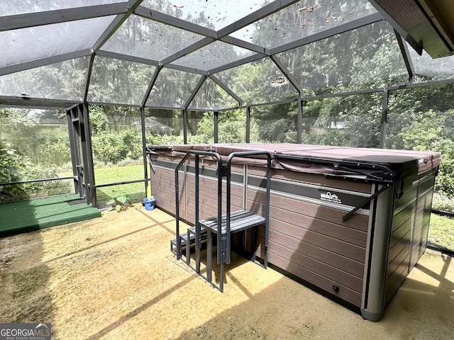 view of patio / terrace with glass enclosure and a hot tub