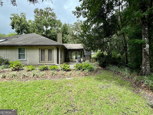 back of property with a lawn and a patio