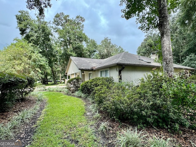 view of property exterior featuring a lawn