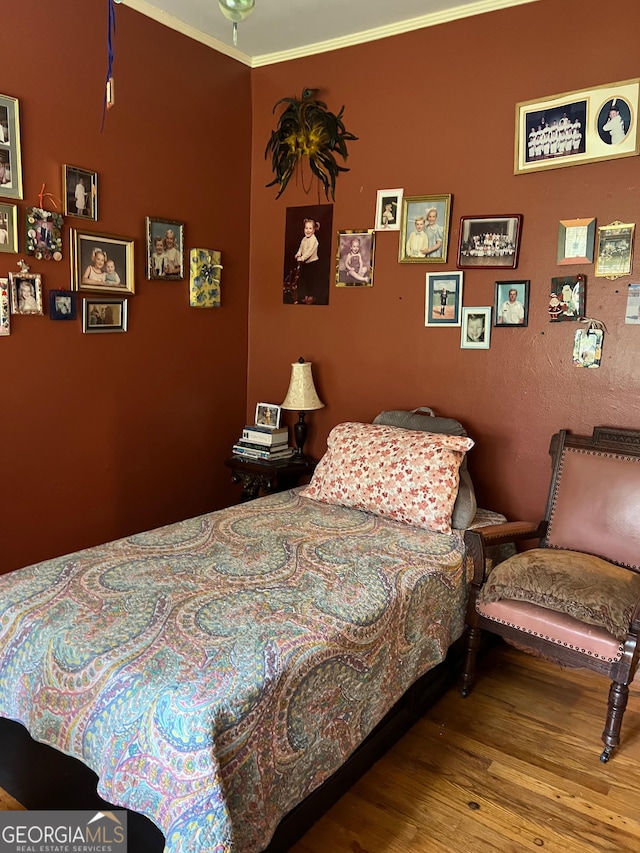 bedroom featuring ornamental molding and wood-type flooring