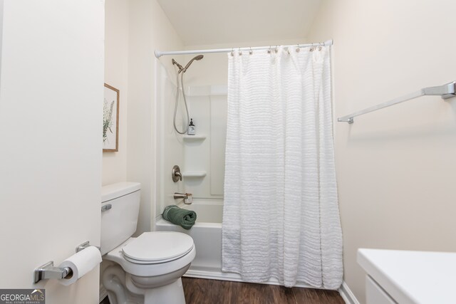 bathroom featuring shower / bath combo with shower curtain, hardwood / wood-style floors, and toilet