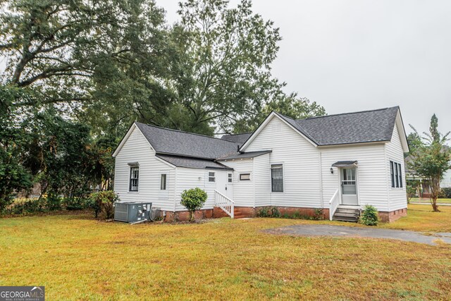 view of front of house featuring central air condition unit and a front yard