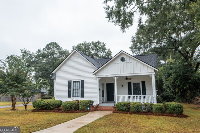 bungalow-style home featuring a front yard, covered porch, and ceiling fan