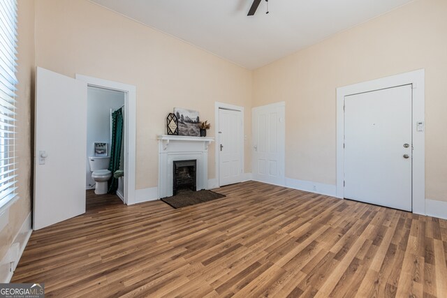 unfurnished living room featuring wood-type flooring and ceiling fan