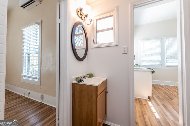 bathroom with vanity, a wall unit AC, and hardwood / wood-style flooring