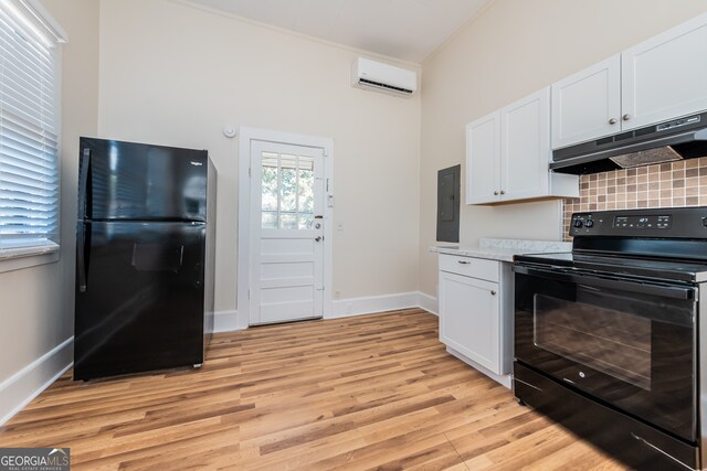 kitchen featuring light wood-type flooring, black appliances, white cabinetry, and an AC wall unit