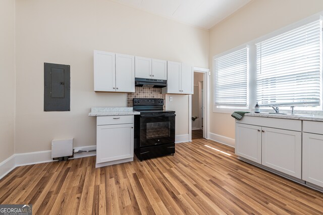 kitchen featuring black / electric stove, light hardwood / wood-style flooring, electric panel, and sink