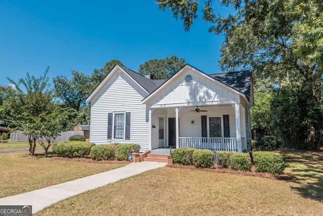 view of front facade with ceiling fan, covered porch, and a front yard