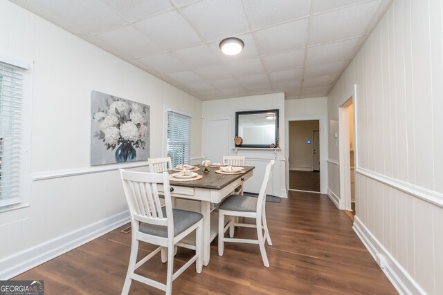 dining room with dark hardwood / wood-style flooring and a drop ceiling