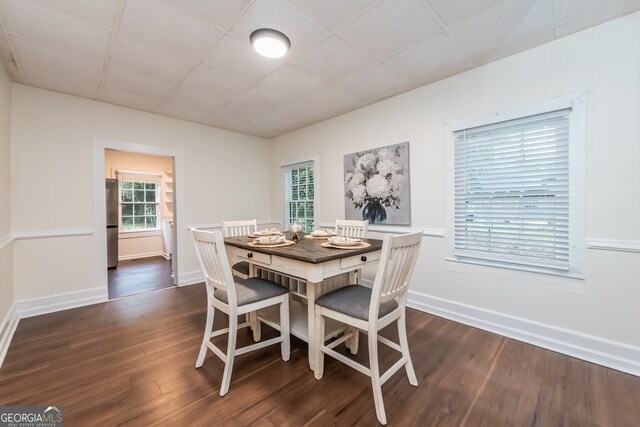 dining area featuring a paneled ceiling and dark hardwood / wood-style floors