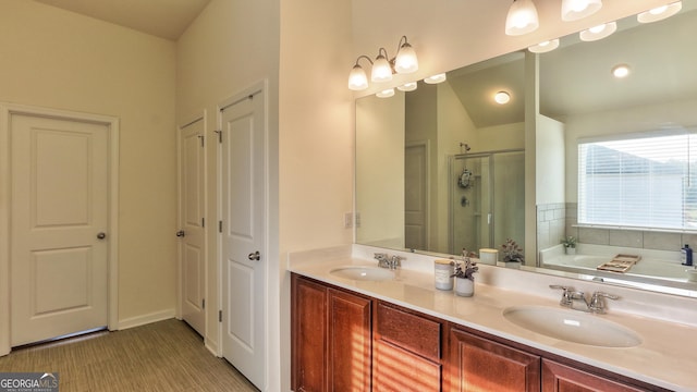 bathroom with vanity and shower with separate bathtub